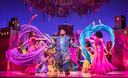 07 Genie (Trevor Dion Nicholas) in market surrounded by scarfs - photo by Johan Persson � Disney